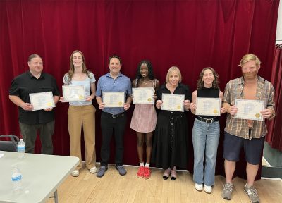 The group of participants holding their certificates and posing after class.