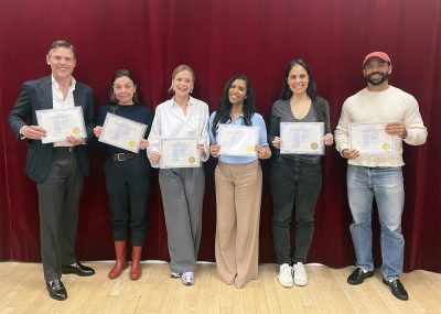 The participants of Herman's public speaking class holding up their certificates.